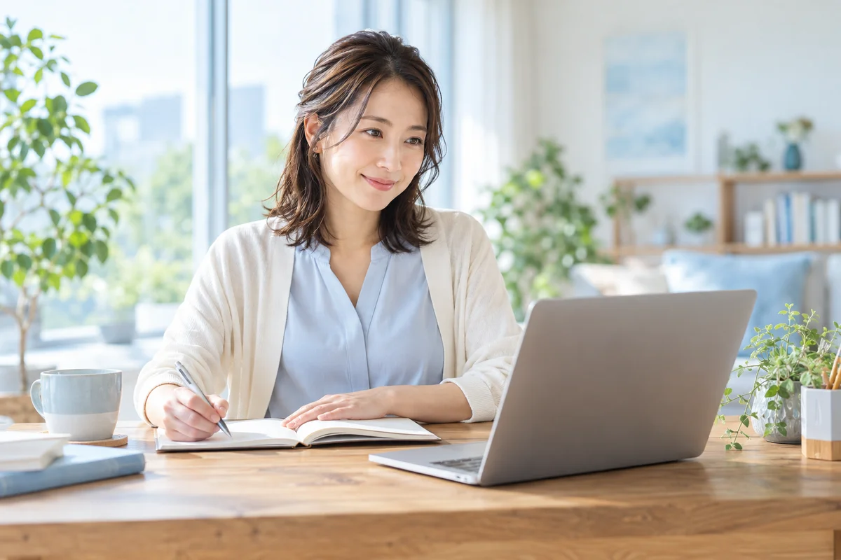 パソコンとノートを使って学習に取り組む人